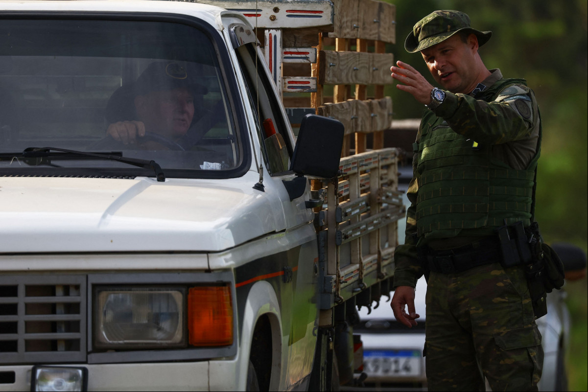  An agent of the Environmental Patrol of the Military Brigade (PATRAM) checks a vehicle close to a commercial poultry farm, the site of the country's first bird flu outbreak, in Montenegro, Rio Grande do Sul state, Brazil, on May 17, 2025. China and the European Union have suspended imports of chicken meat from Brazil, the world's biggest exporter of the commodity, after an outbreak of bird flu on a farm in the South American country, officials said Friday. 
