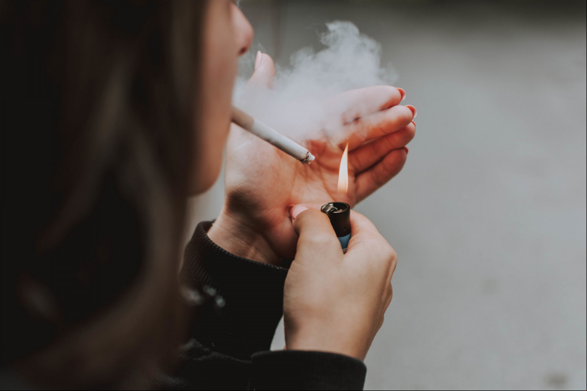Mulher segurando um cigarro aceso (Freepik) Mulher segurando um cigarro aceso/Freepik